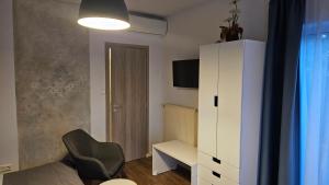 a small room with a white cabinet and a chair at Sunlight Apartmanház in Velence