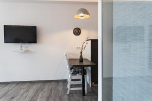 a dining room with a table and a tv at Black & White in Ilmmünster