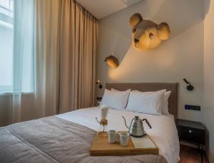 a hotel room with a bed with a teddy bear on the wall at Artagonist Art Hotel in Vilnius +78 photos