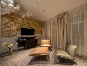 uma sala de estar com duas cadeiras e uma televisão em Artagonist Art Hotel em Vilnius