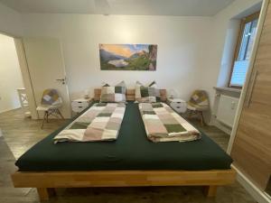 a large bed in a room with chairs at Ferienwohnung Bergblick in Marquartstein