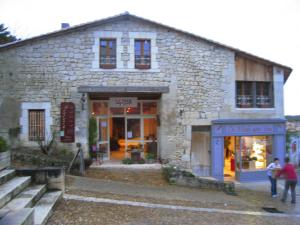 a stone building with a store in front of it at "Côté plage" in Aubeterre-sur-Dronne
