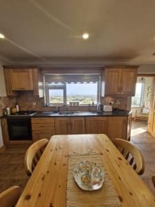 a kitchen with a wooden table with chairs and a tableablish at Teach na hAirde in Carna +29 photos