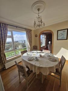 a dining room with a table and a large window at Teach na hAirde in Carna