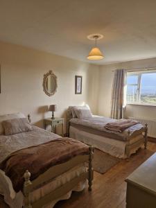 a bedroom with two beds and a window at Teach na hAirde in Carna