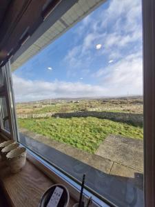 a window with a view of a green field at Teach na hAirde in Carna