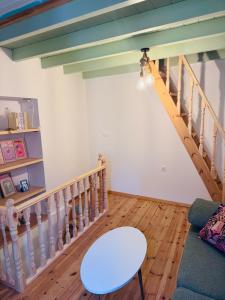 a living room with a staircase and a table at La Maisonette de Symi in Symi