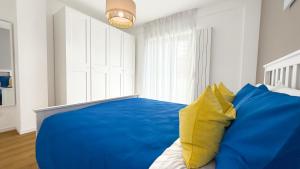 a blue and yellow bed in a white bedroom at Platinum House in Montesilvano