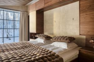 a bedroom with two beds and a large window at Taikavilla in Kuusamo