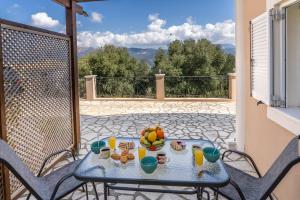 a table with a bowl of fruit on a balcony at Avra Charming House in Khelmáta +39 photos
