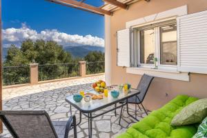 a patio with a table and chairs on a balcony at Avra Charming House in Khelmáta