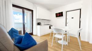 a white living room with a table and chairs at Platinum House in Montesilvano