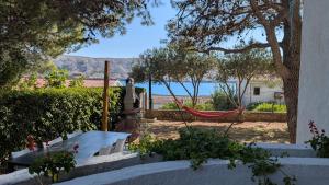 a hammock in a garden with a view of the water at Apartments Tea Pag in Pag