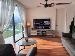 a living room with a couch and a flat screen tv at Sunway Onsen Suite in Tambun