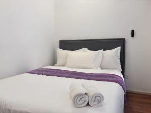 a bedroom with a white bed with two towels at Sunway Onsen Suite in Tambun +106 photos