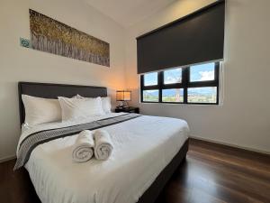 a bedroom with a bed with two towels on it at Sunway Onsen Suite in Tambun