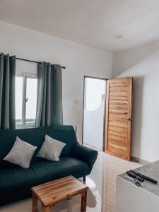 a living room with a green couch and a table at L.C. Apartments in Lamai