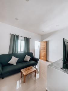 a living room with a green couch and a table at L.C. Apartments in Lamai