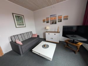 a living room with a couch and a flat screen tv at Alte Stadthauswohnung mit Flair in Celle
