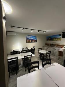 a dining room with white tables and chairs at Hotel HER in Vlorë