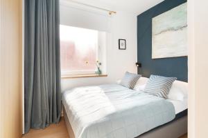 a bedroom with a bed with blue walls and a window at Waldstraße 2 Windrose Kellenhusen in Kellenhusen