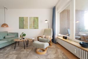 a living room with a couch and a chair at Waldstraße 2 Windrose Kellenhusen in Kellenhusen