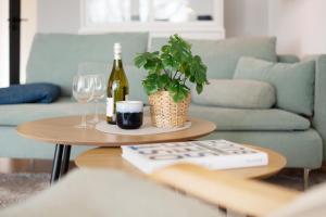 a table with a bottle of wine and a plant at Waldstraße 2 Windrose Kellenhusen in Kellenhusen +36 photos