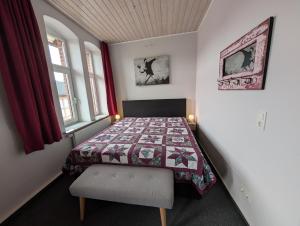 a small bedroom with a bed with a quilt on it at Alte Stadthauswohnung mit Flair in Celle