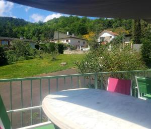 a table and chairs on the balcony of a house at La Villa Pauze in Royat