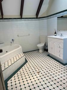 a bathroom with a tub and a toilet and a sink at Hahndorf Motel in Hahndorf +18 photos