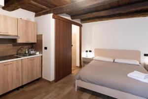 a bedroom with a bed and a kitchen with wooden ceilings at Wake&Relax in Decollatura