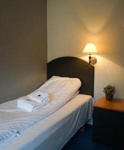 a hotel room with a bed with towels on it at Lindum Hotell in Bergjord