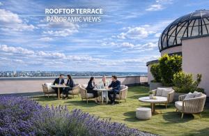 people sitting at tables on a roof top terracearma views at Don Giovanni Hotel Prague - Great Hotels of The World in Prague