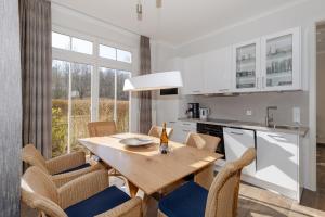 a kitchen and dining room with a wooden table and chairs at Dünenschloss in Kühlungsborn