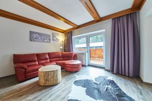 ein Wohnzimmer mit einem roten Sofa und einem Tisch in der Unterkunft Holiday Home Viehhofen in Viehhofen