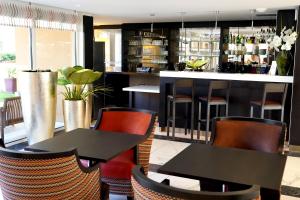 a restaurant with two tables and chairs and a bar at Appart One Uzès in Uzès