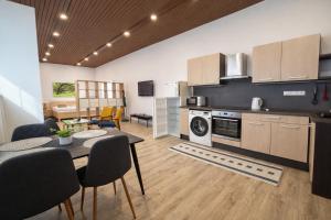 a kitchen and living room with a table and chairs at Hotel Kristína in Dubnica nad Váhom