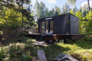 a small black tiny house in a yard at Kakupesa Puhkemaja in Hara