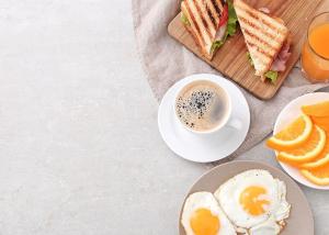 a plate of food with a sandwich and a cup of coffee at Hotel Ashram View With Luxury Near Nizamuddin Railway Station in New Delhi