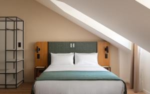a bedroom with a large bed in a attic at Limehome Versailles Rue du Bailliage in Versailles +42 photos