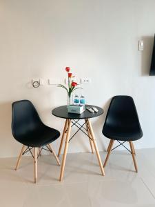 two black chairs and a table with a vase on it at Royal Oceancrest Panglao 1020 in Dao