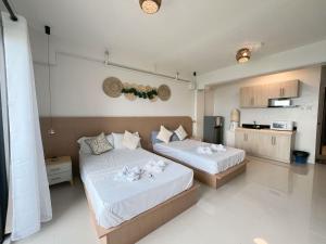 a bedroom with two beds and a kitchen at Royal Oceancrest Panglao 1020 in Dao
