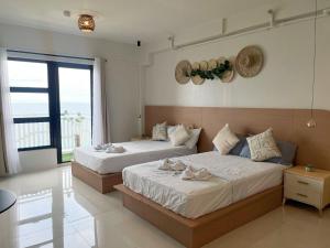 a bedroom with two beds and a large window at Royal Oceancrest Panglao 1020 in Dao