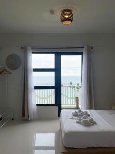 a bedroom with a bed and a large window at Royal Oceancrest Panglao 1020 in Dao
