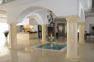 a lobby with a fountain in the middle of a building at Hotel Menara in Hammamet