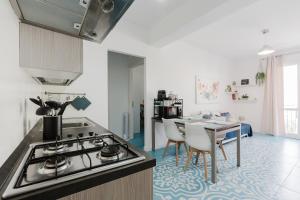 a kitchen with a stove and a table with chairs at Orizzonte Blu apartment - Macari Bay in Macari