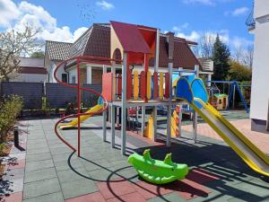 a playground with a slide in front of a house at Villa Sovita in Łeba