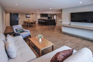 a living room with a couch and a television at Alpine Golf Resort Chiang Mai in Ban Huai Sai Nua