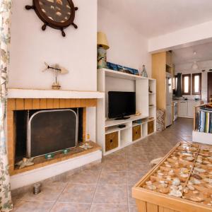 a living room with a fireplace and a tv at Emma's HOUSE near beach in Tsakaíoi