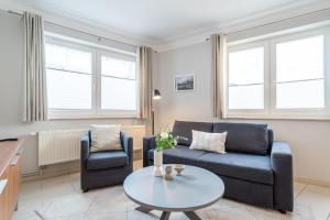 a living room with a couch and two chairs and a table at Villa Seedüwel - App C01 in Ahlbeck